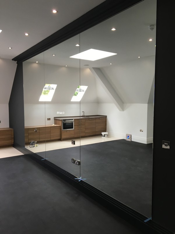 Frameless glass partition in loft conversion by London glaziers