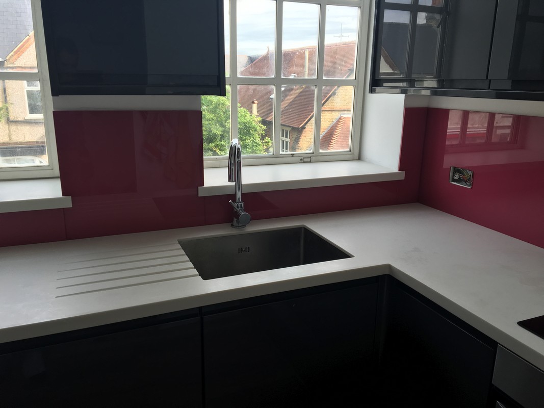Deep plum coloured glass splashback in modern London kitchen